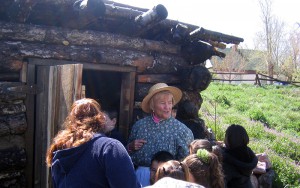 adult and children in front of root cellar