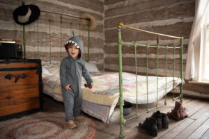 child in cabin standing by bed
