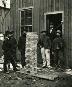stack of silver bricks with men looking on