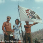 three people standing with a flag